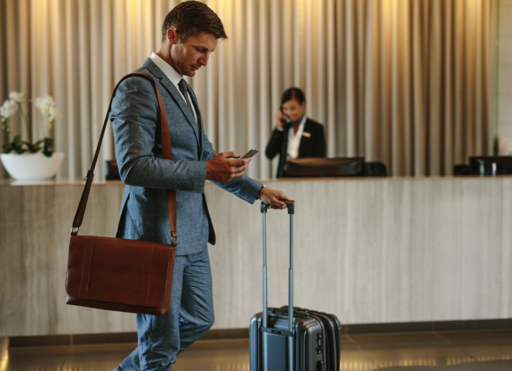 Biznesmen z walizką podczas zameldowania w hotelu.